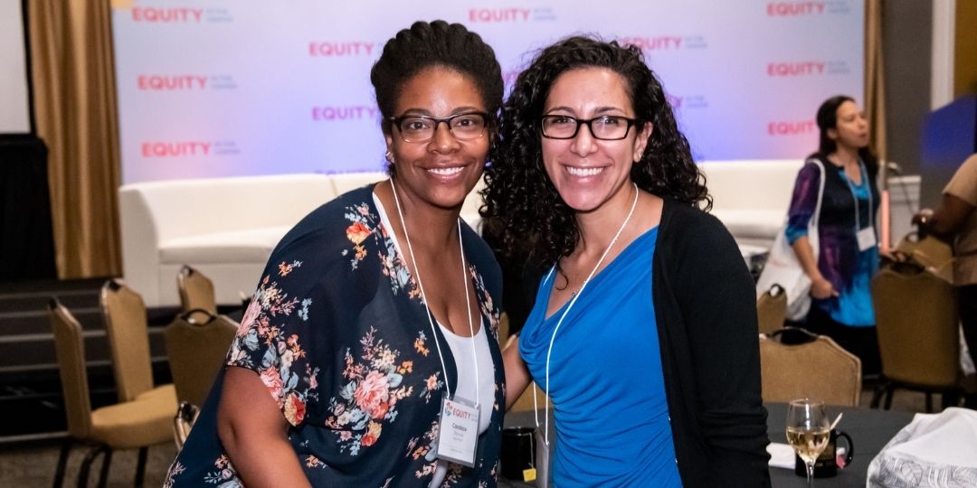 Two people posing for photo at EiC conference. Both are wearing glasses and are smiling.