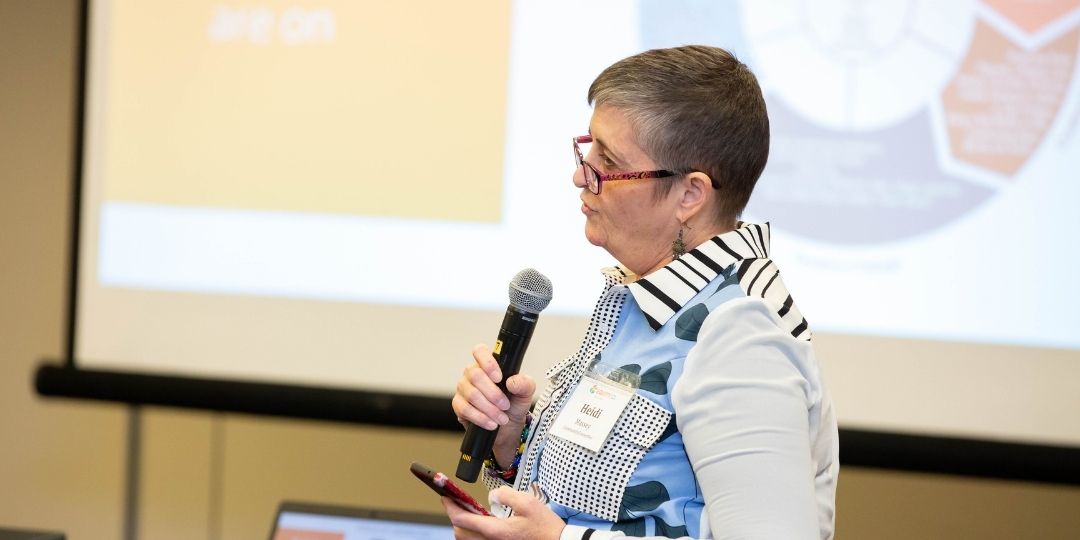 Person presenting at conference holding a microphone